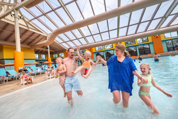Family playing in the shoreline of the wavepool in the Wild WaterDome