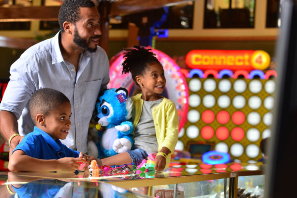 Father and two young kids at the Arcade's redemption picking out prizes